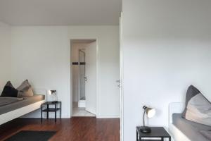 诺德施泰特Ferienwohnung Ohechaussee的卧室设有白色的墙壁、一张床和镜子