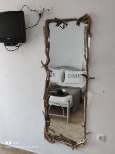 萨索斯Moschoula Villa - Apartment 1的一面带木框的镜子、一张床和一台电视