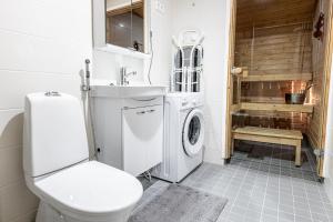 赫尔辛基SleepWell Apartment Rio- Tyynimeri with private sauna and parking的一间带卫生间和洗衣机的浴室
