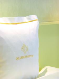 富尔达Hotel Goldener Karpfen OHG的床上的白色袋子,上面有标志