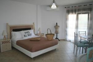 萨索斯Moschoula Villa - Apartment 1的卧室配有一张床和一张桌子及椅子