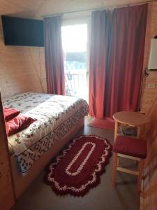 珀尔瓦Metsjärve mini puhkemaja的一间卧室配有一张床、一张桌子和一个窗户。