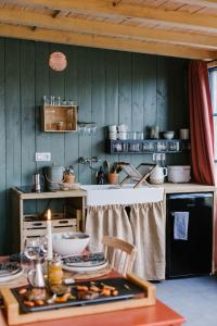西内La cabane du potager - Ferme de Linciaux的厨房配有餐桌和食物