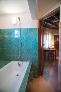 瓦加杜古格兰德卡劳宾馆的浴室配有绿色瓷砖和浴缸
