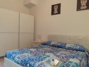 陶尔米纳Castel Tauro Apartment的一间卧室配有一张带蓝色和白色棉被的床
