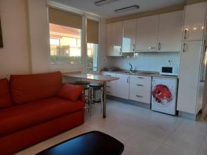 林克勒斯波提欧海滩公寓的一间带红色沙发的客厅和一间厨房