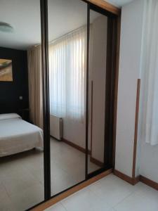 林克勒斯波提欧海滩公寓的卧室配有一扇镜子,卧室配有一张床,卧室配有一张床。