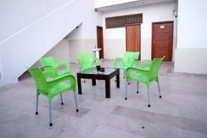 卡拉奇Seasons Inn的配有绿色椅子、桌子和楼梯的房间