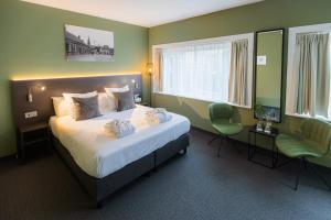 埃因霍温Hotel Parkzicht Eindhoven的酒店客房,配有一张床和两把椅子