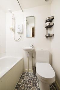 伦敦Charmstay King's Cross的浴室配有卫生间、盥洗盆和浴缸。