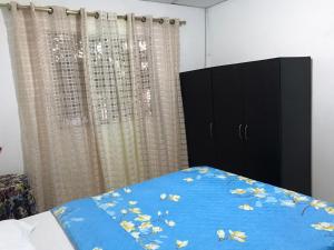 里奥阿查Apartamento Cómodo的一间卧室配有一张带蓝色床单和窗帘的床