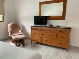 坎昆Closetoairport的一间卧室配有带电视和椅子的梳妆台