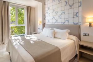塞维利亚圣巴勃罗塞维利亚酒店的一间卧室设有一张大床和一个窗户。
