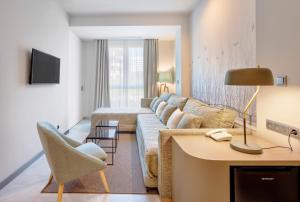 塞维利亚圣巴勃罗塞维利亚酒店的客厅配有沙发和桌子
