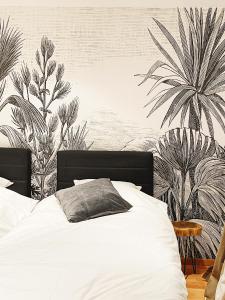 昂内Le Pact - Gîte familial的卧室配有白色的床和棕榈树壁画