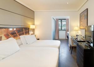 巴塞罗那H10大学酒店的酒店客房设有一张大床和一张书桌。