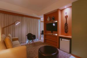 若昂佩索阿绿茵酒店的客厅配有沙发和电视。