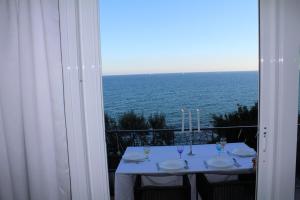 玛丽安迪安多拉Conca Verde c21- BEACH FRONT little villa- POOL, private JACUZZI sea view的阳台的桌子享有海景