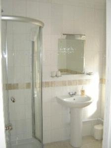 剑桥列文顿别墅酒店的白色的浴室设有水槽和淋浴。
