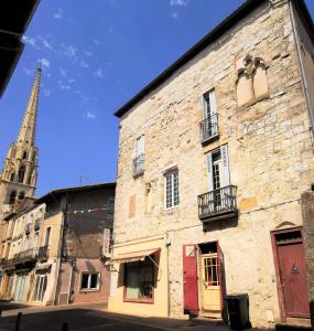 大圣富瓦Maison de caractère dans la bastide foyenne的一座古老的石头建筑,后面有一座教堂