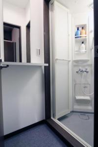 东京BEE-HIVE巣鴨(Sugamo)【男性専用・Male Only】的客房内的白色冰箱,玻璃门