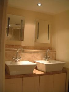 佩恩斯威克Tibbiwell Lodge的浴室设有2个水槽和2面镜子