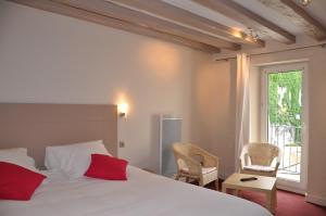 艾克斯莱班德拉库罗讷酒店的卧室配有白色的床、红色枕头和窗户