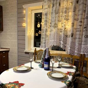 亚列姆切Котедж ''Олечка''的一张桌子,上面放着一瓶葡萄酒和眼镜