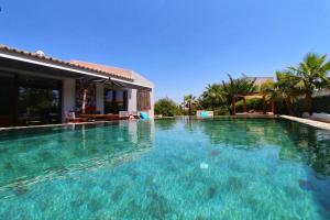 Mexilhoeira GrandeBeautiful Algarve Pool Villa Bali 15min to beach的一座房子前面的蓝色海水大型游泳池