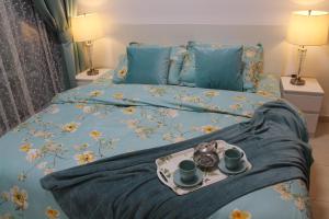 迪拜Newly furnished One Bedroom Apartment next to Metro & Beach in Marina Residence的一张带盘子的床上,上面有两杯