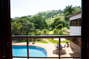 阿瓜斯迪林多亚Pousada Costa Rielli的享有游泳池景致的阳台