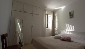 SavarApartman Lapis的一间白色卧室,配有一张床和一个梳妆台