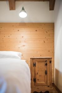 圣洛伦佐-迪塞巴托Hotel Hurtmuehle Kronblick的卧室配有白色的床和木墙