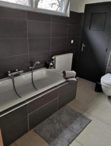 那慕尔LA SUITE 159的带浴缸和卫生间的浴室。