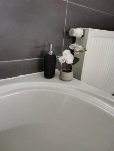 那慕尔LA SUITE 159的白色浴缸,配有肥皂机和鲜花