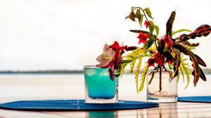 阿鲁坦加艾图塔基村酒店的两瓶花花瓶和桌上的饮料