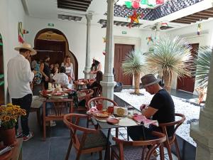 瓦哈卡市Casa Naila Hotel Boutique的一群坐在餐厅桌子上的人