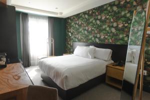 萨卡特卡斯Matiana Morelos的一间卧室设有一张带花卉墙壁的大床