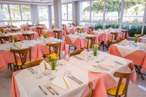 瓜鲁雅Doral Guarujá的宴会厅配有桌椅和橙色桌布