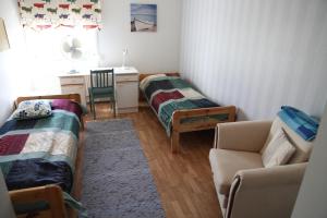 NorinkyläOpintola Bed & Breakfast的客房设有两张床、一张桌子和一张沙发。