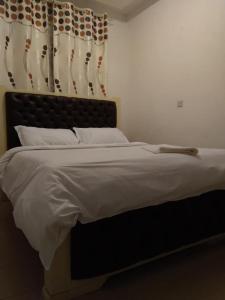 NarokLux Suites Mara Holiday Homes的一间卧室配有一张大床和黑色床头板