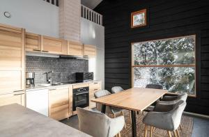 鲁卡Villa Ruka - Rising Sun的厨房配有木桌、椅子和窗户。