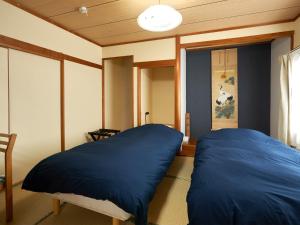 千岁LY INN CHITOSEAIPORT - Vacation STAY 94792的一间设有两张蓝色枕头的床的房间