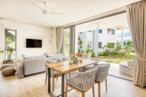 马埃岛贝拉扎尔区Pineapple Beach Villas的客厅配有桌椅和沙发