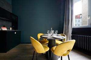 柏林numa l Sketch Rooms & Apartments的一间带桌子和黄色椅子的用餐室