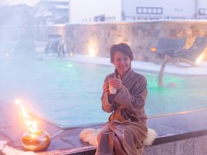 弗劳埃瑙圣佛罗莱恩酒店的坐在游泳池旁的女人们,带蜡烛
