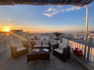 奥斯图尼800s Home Luxury Rooms的一个带桌椅的阳台,享有日落美景