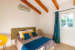 AregnoAria - Vue Mer的一间卧室配有蓝色和黄色枕头的床