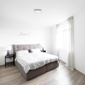 不来梅港Moderne 2 Zimmer Ferienwohnung mit Dachterrasse - 95qm的白色的卧室设有一张大床和一个窗户