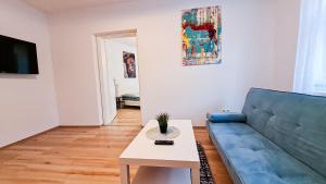 纽伦堡Luxuriöses Apartment im Zentrum von Nürnberg的客厅配有蓝色的沙发和桌子